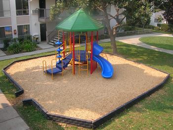 A playground with a green canopy and a blue slide.